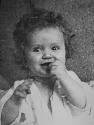 a black and white photo of a little girl eating something